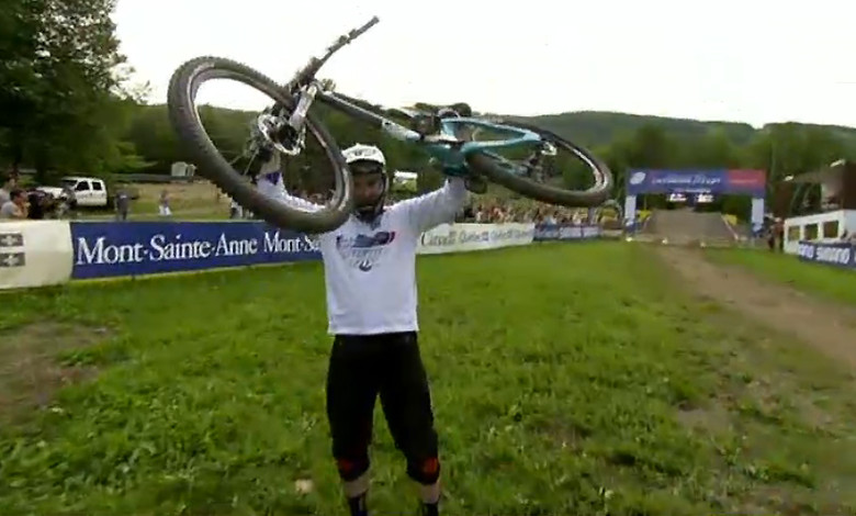 A victorious Jared Graves hoists his bike at the finish line.