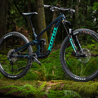 Picture of Kona Process X sitting on a log in the woods